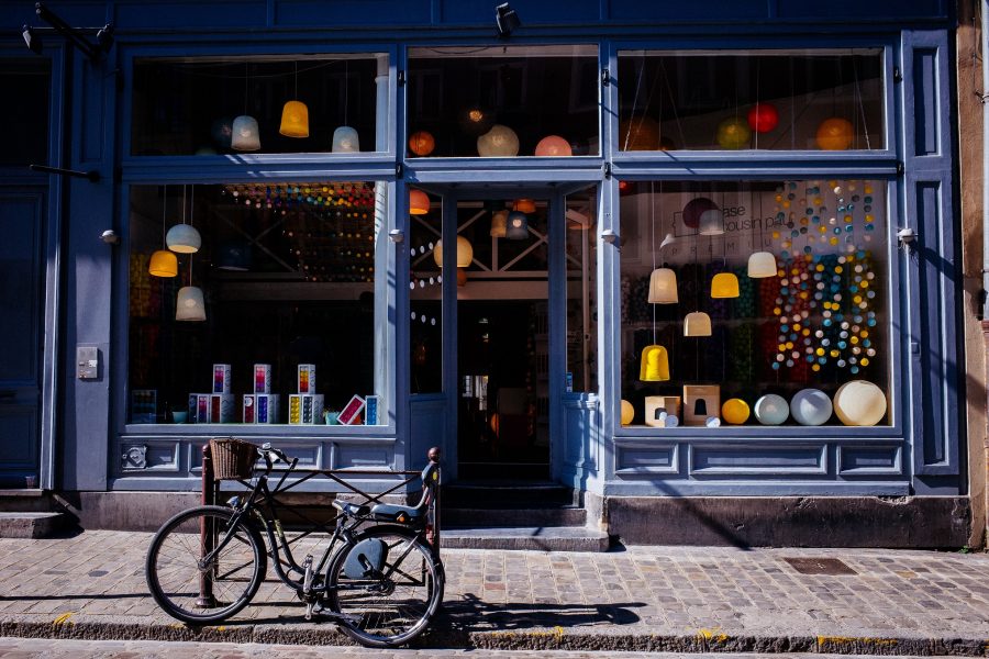 A colorful storefront in a historic downtown area with a bicycle parked outside.