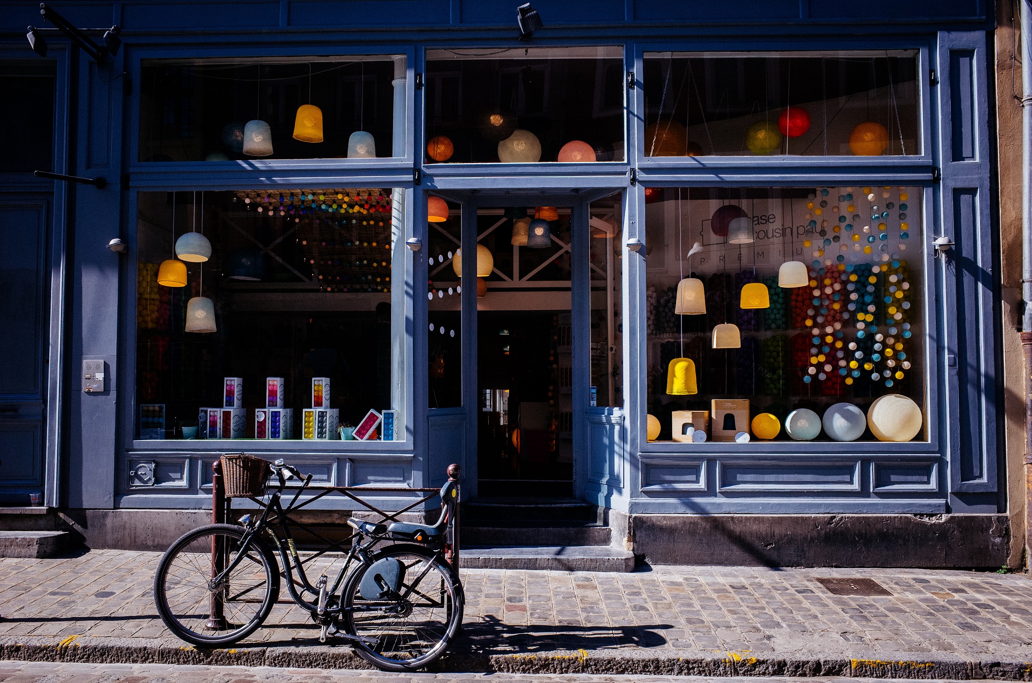 A colorful storefront in a historic downtown area with a bicycle parked outside.