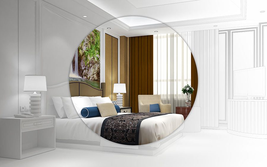 The inside of a modern, high class hotel room with a bed, end tables, lamps, and a small table and chair.