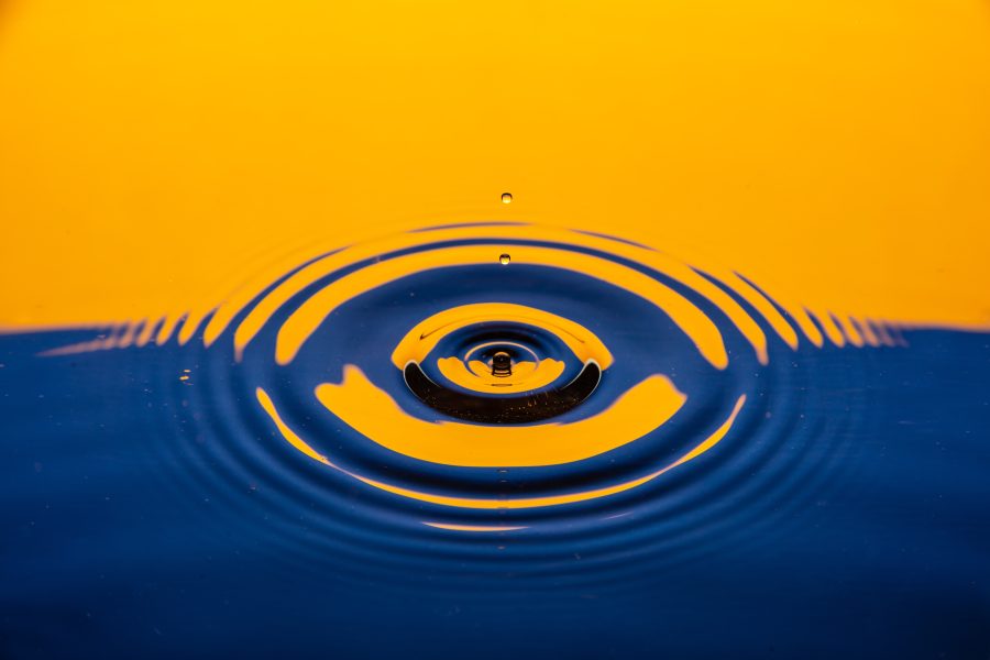 A brightly tinted image of the ripples produced by a water droplet on a pond