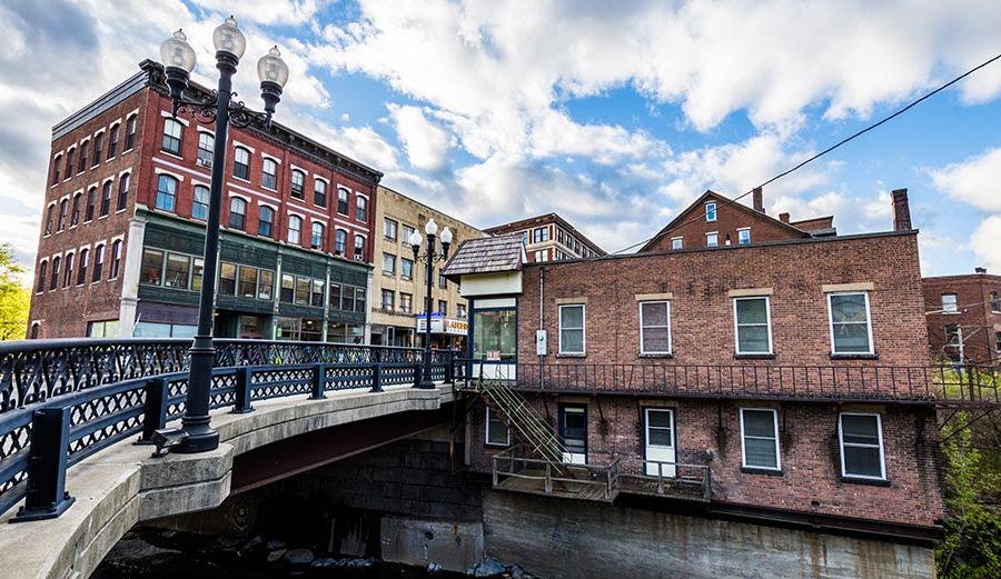 A small bridge over Whetstone Creek is flanked by historical commercial and residential buildings on the south end of Main Street in Brattleboro, Vermont.