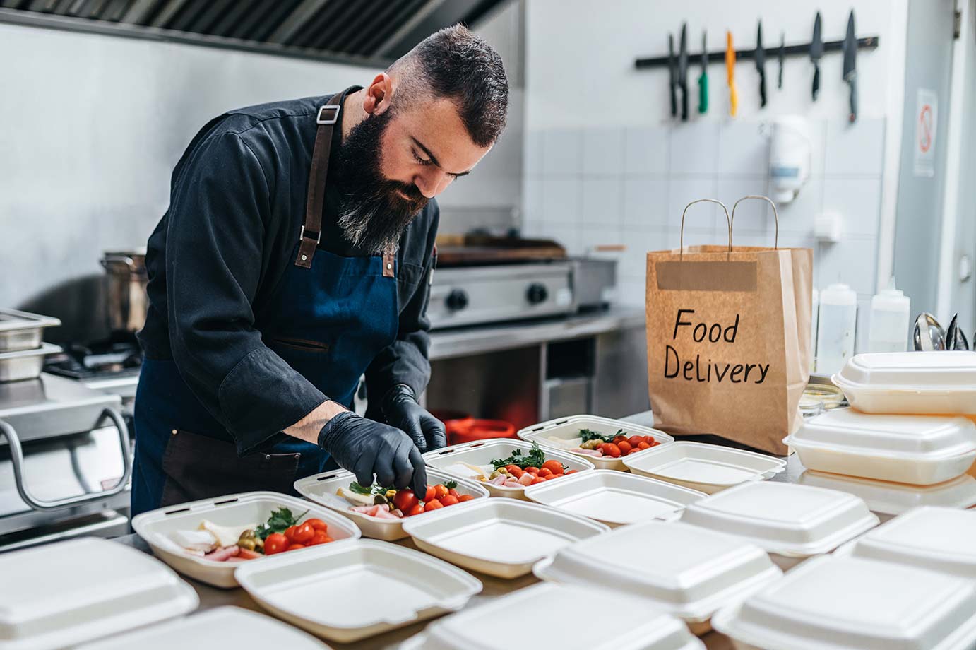 A chef prepares multiple meals for delivery.
