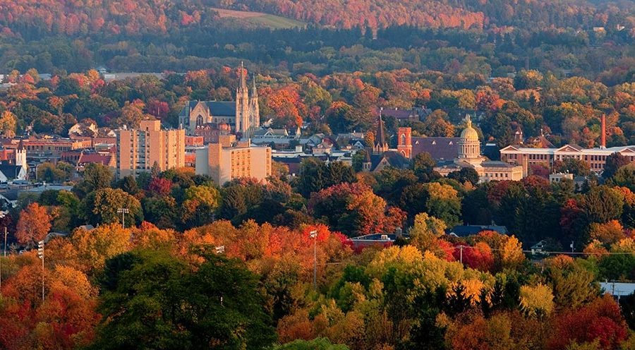 Aerial photo of a city in Central New York State surrounded by beautiful trees in the fall