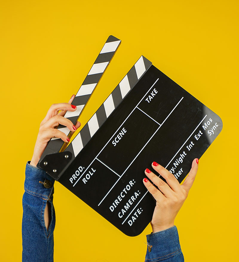 A film production clapper board is held aloft