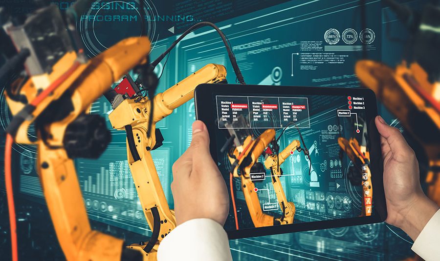 A person uses a tablet computer to operate advanced manufacturing equipment in a factory