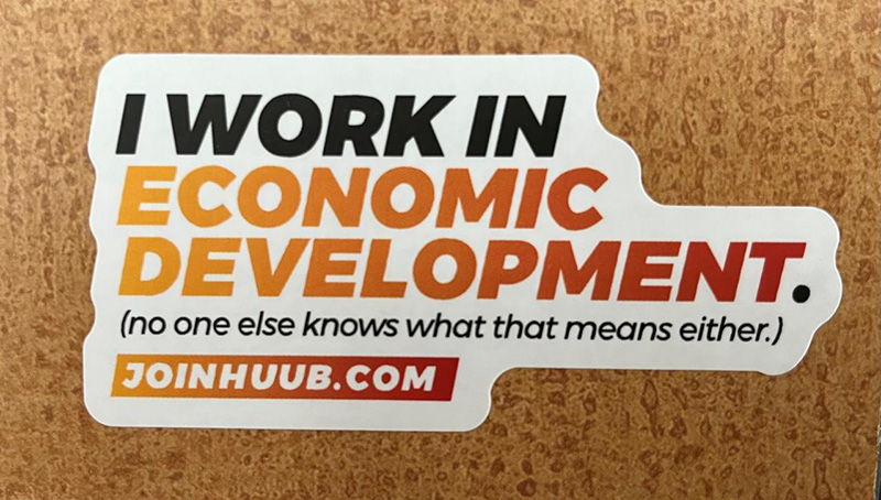 A picture of a sticker that reads "I work in economic development. (No one else knows what that means either.)"