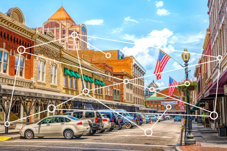 Photo of a downtown shopping area with network/connection lines between buildings and other objects illustrates an entrepreneurial ecosystem