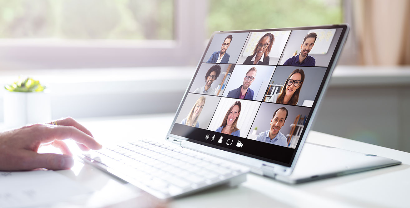 A person uses a laptop computer to provide virtual training for nine other people.
