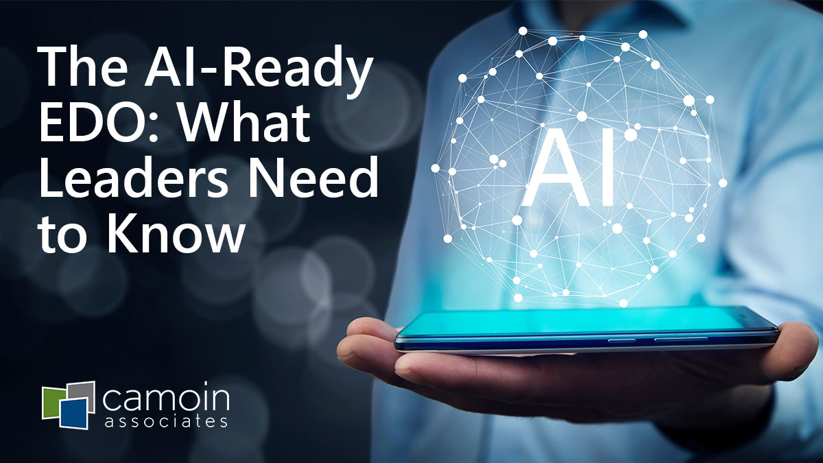 A man in a light blue button-down shirt holds a smartphone in his open palm with "AI" floating above it, along with other related technology symbols. Next to the image is text that reads: The AI-Ready EDO: What Leaders Need to Know, along with the Camoin Associates logo.